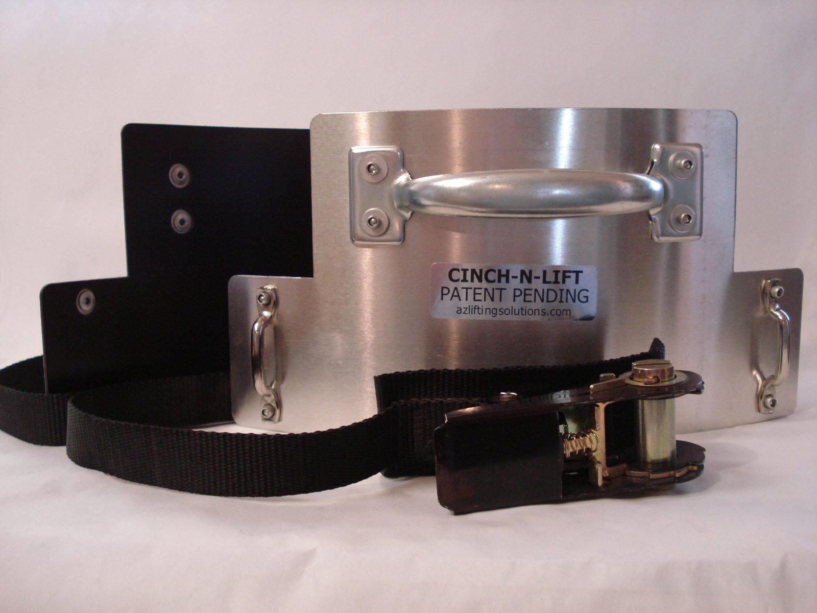 A CINCH-N-LIFT handle: brushed aluminium plate with a carry handle, side grips and a ratchet strap