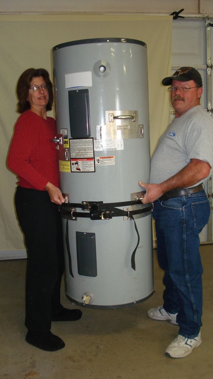 A man and a woman lifting a water heater together